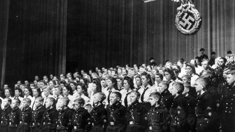 Hitler Youth in 1940 with swastika in background