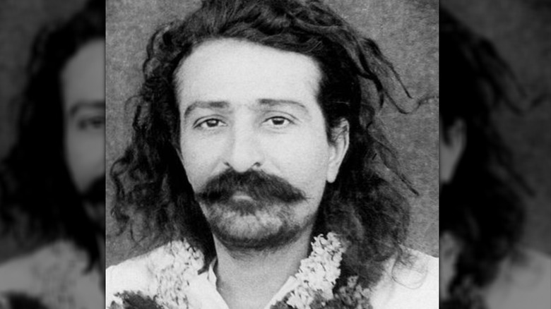 Meher Baba in flower necklace