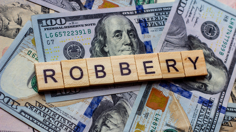 Photo of the word "robbery" on pile of money