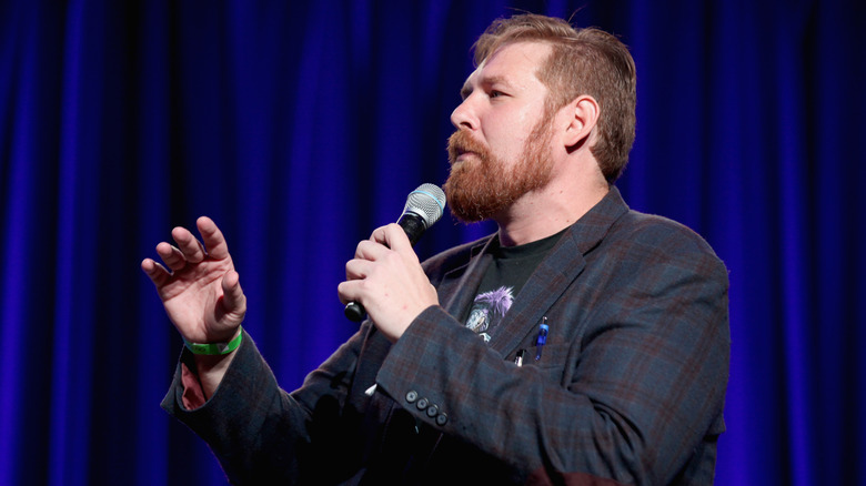 Ben Kissel speaking into a microphone onstage