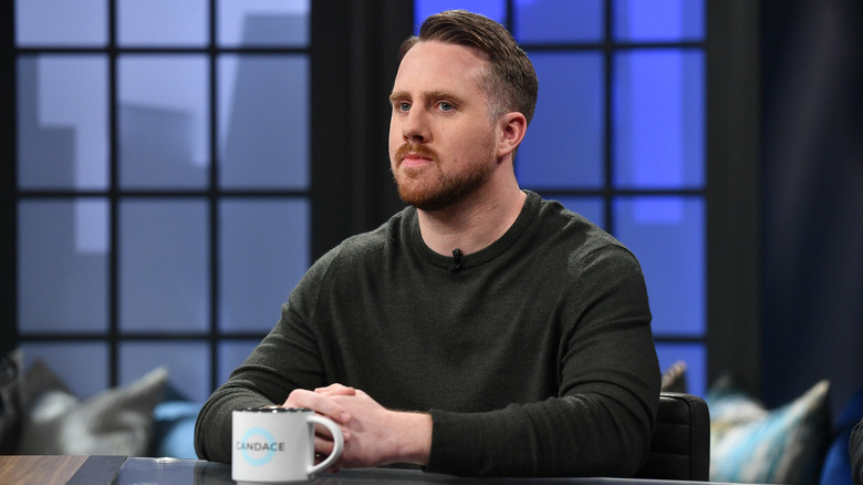 Elijah Schaffer seated at a desk with coffee cup