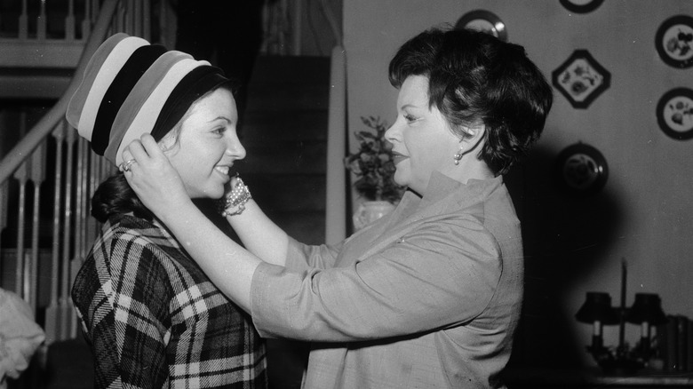 Judy helps Liza try on hat