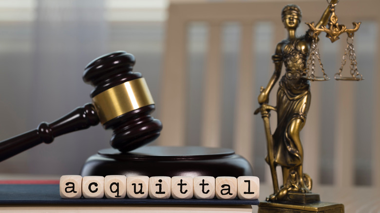 word acquittal beside gavel and scales 