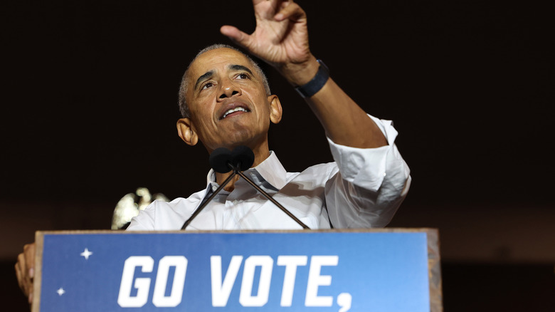 Obama speaking at podium hand raised