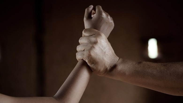 man grabbing woman's arm