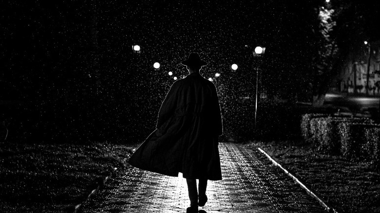 man in coat dark street