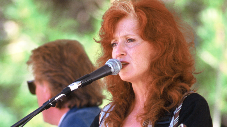 Bonnie Raitt singing into microphone