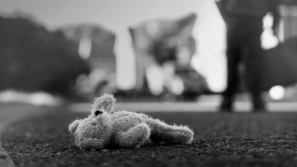 Teddy bear lying on the ground in black and white