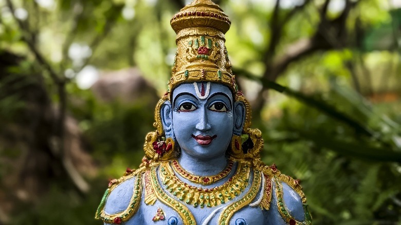 painted Vishnu statue forest background