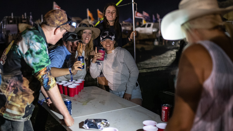 Beer pong players at a festival