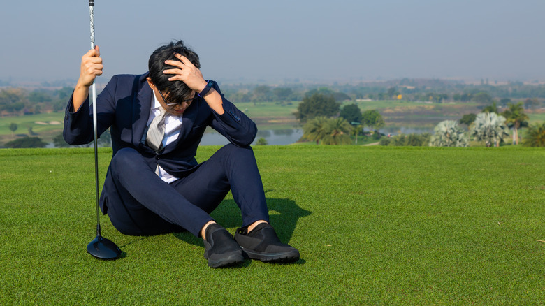 golfer in suit covering head