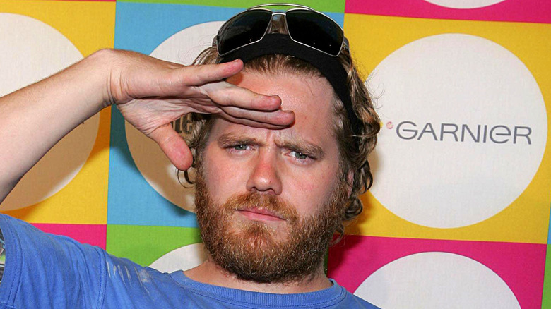 Ryan Dunn saluting blue shirt sunglasses on head