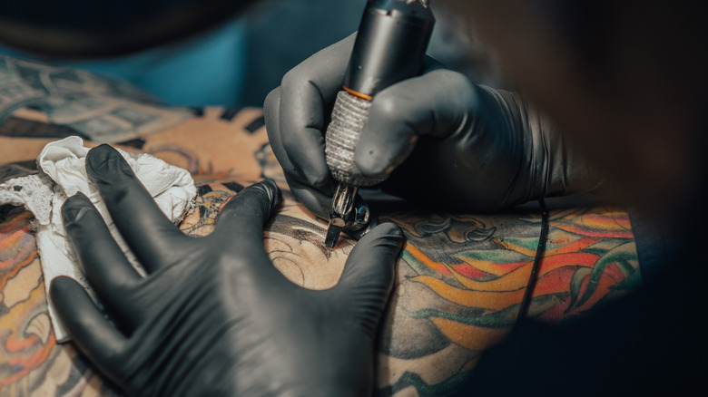 Artist performs tattoo