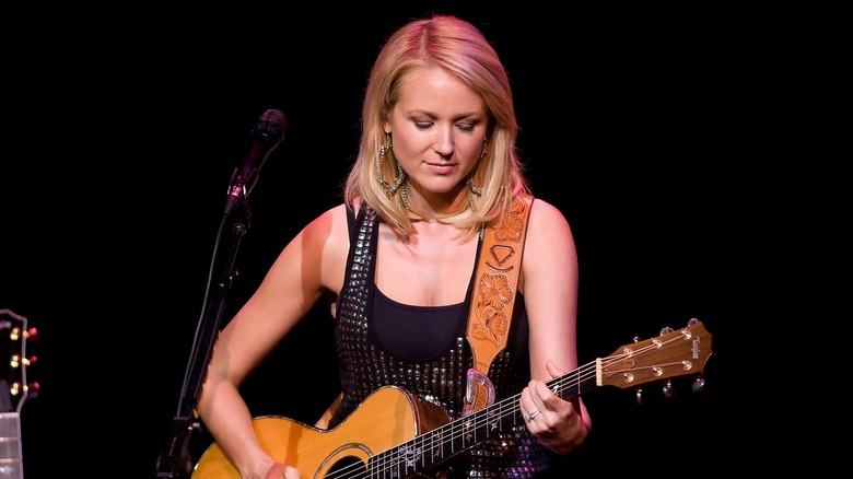 Jewel plays guitar onstage