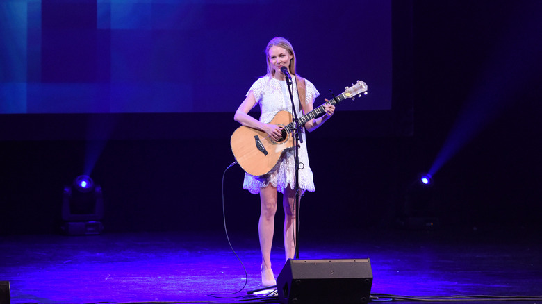 Jewel performs onstage with guitar