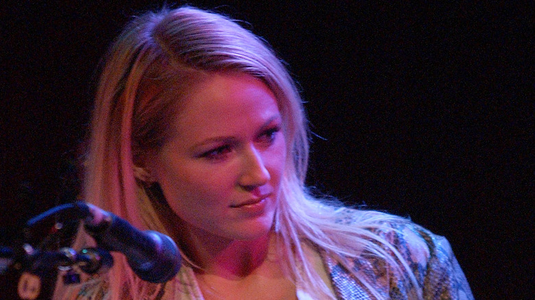 Jewel seated onstage with microphone