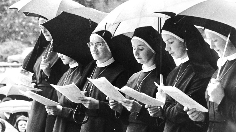 nuns reading under umbrellas
