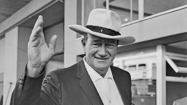 Actor John Wayne waving 