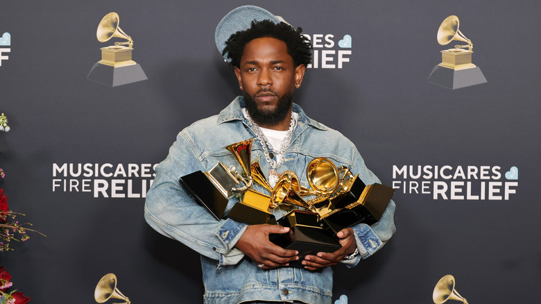 Kendrick Lamar holding his 2025 Grammy awards