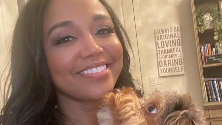 Faith Jenkins smiling with dog at home