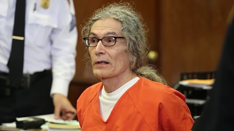 Rodney Alcala looking alarmed in orange jumpsuit in court