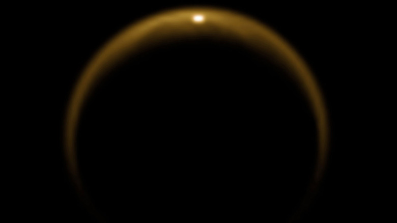 The glint of sunlight shining through Titan's orange haze.