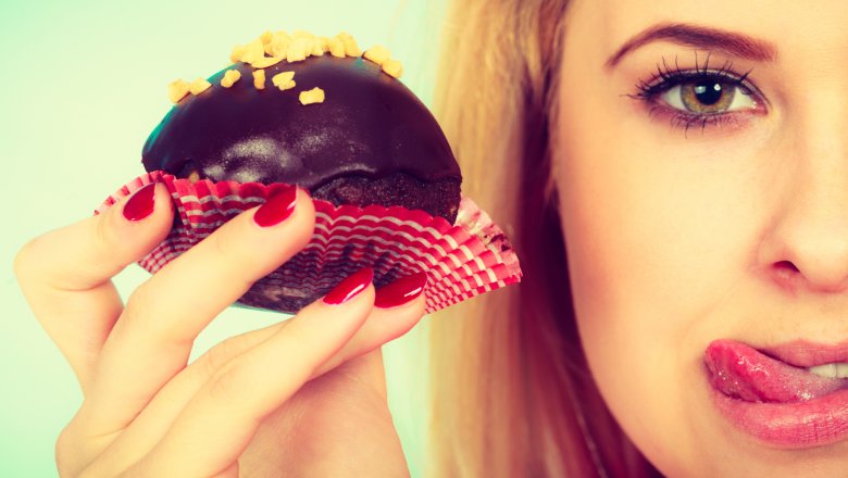 a woman holding up a chocolate dessert