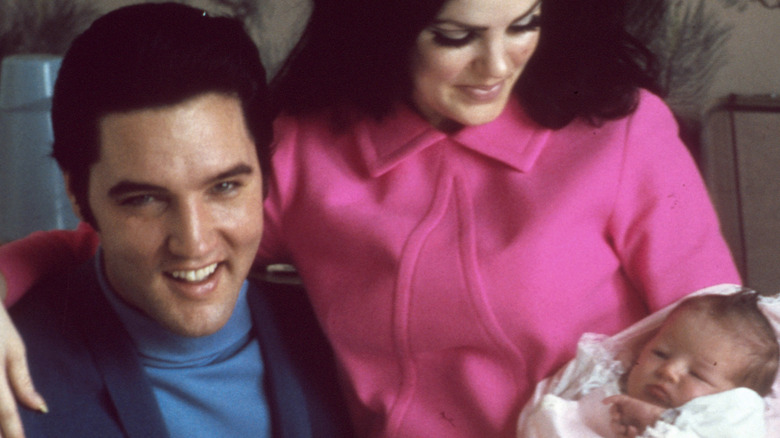 Elvis and Priscilla Presley hold Lisa Marie