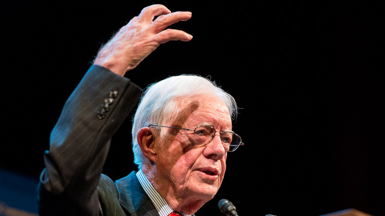 jimmy carter with hand in air