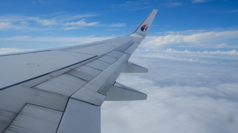 Wing of Malaysia Airlines plane from window