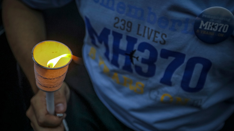 Merson holding candle with rememberence t-shirt