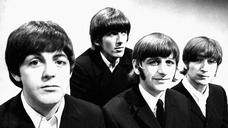 The Beatles posing in black jackets and ties