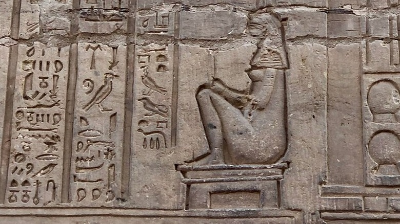 Ancient Egyptian hieroglyph woman sitting on a stool 