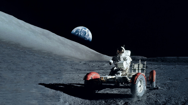 astronaut riding a rover on the Moon