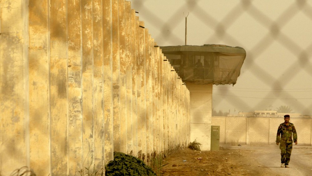 An Iraqi guard patrols the exterior of Abu Ghraib prison after its 2009 reopening