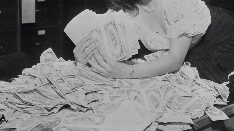 Woman's hands holding piles of dollar bills