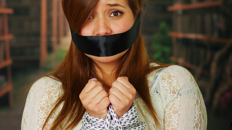 Hispanic woman with black band over mouth