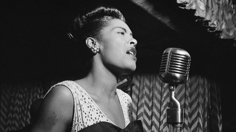 Billie Holiday singing into a microphone