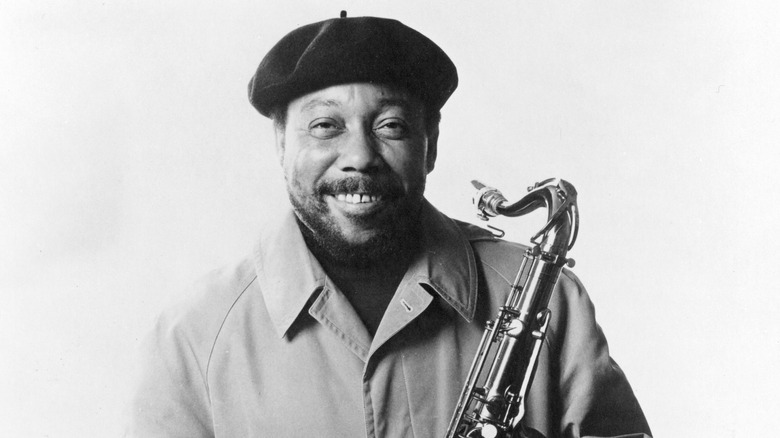 Lucky Thompson smiling holding a saxophone