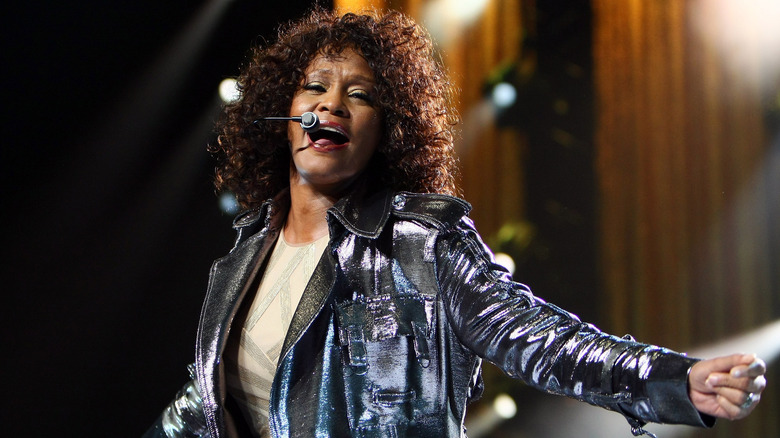 Whitney Houston singing with a headset microphone