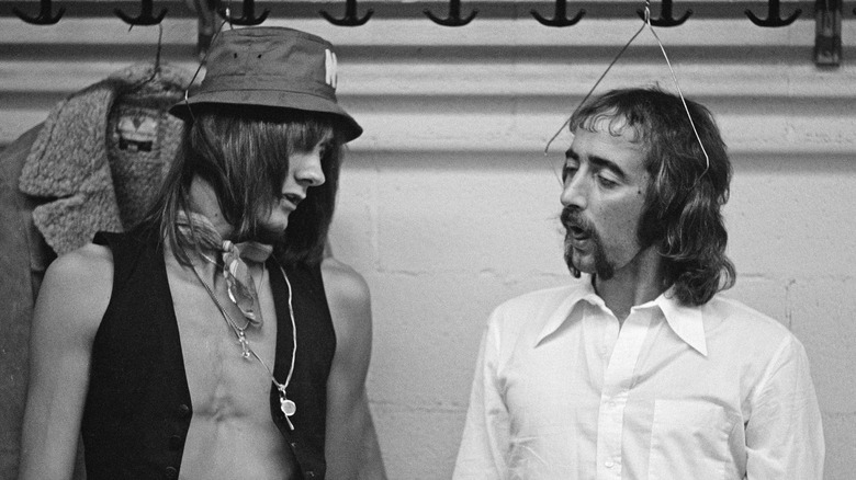 Mick Fleetwood and john McVie hanging from coat hangers in a closet