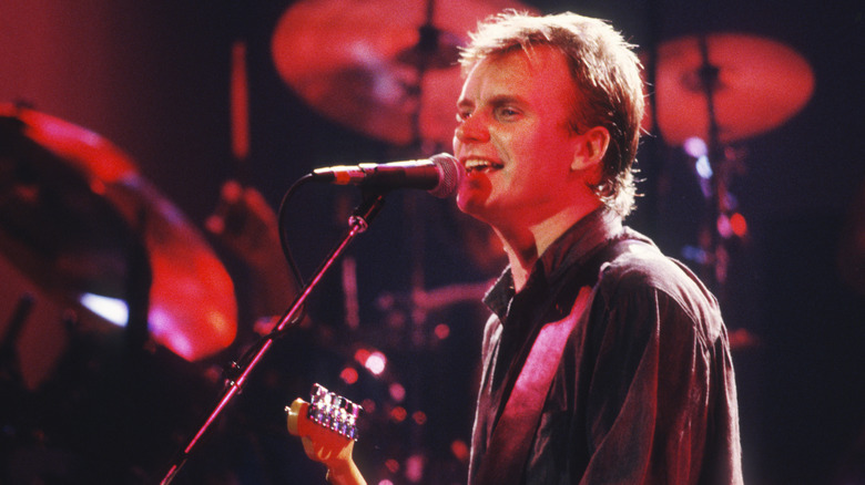 Sting singing into microphone onstage