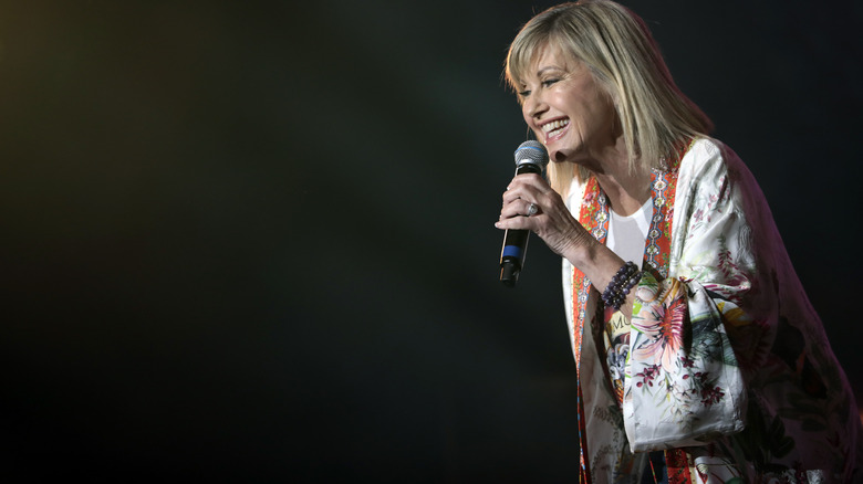 Olivia Newton-John holding a microphone