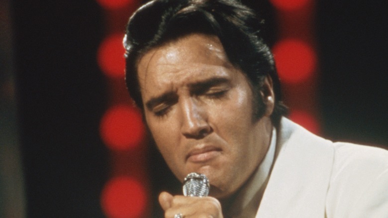 Elvis Presley singing in white suit