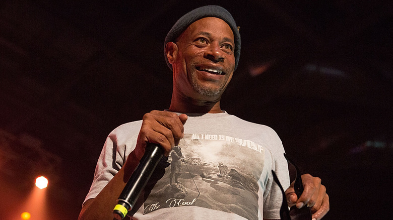 Brother Marquis beanie smiling holding mic onstage