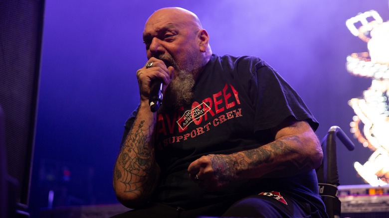 Paul Di'Anno seated in a wheelchair performing onstage