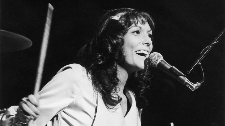 Karen Carpenter playing drums and singing into a microphone