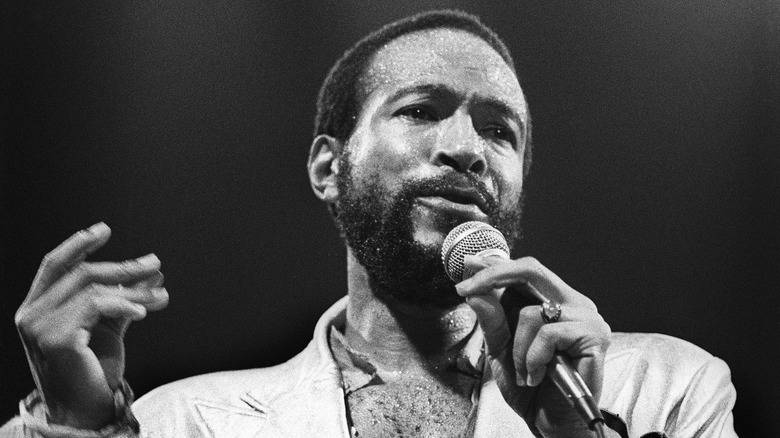 Marvin Gaye singing into a microphone gesturing with one hand