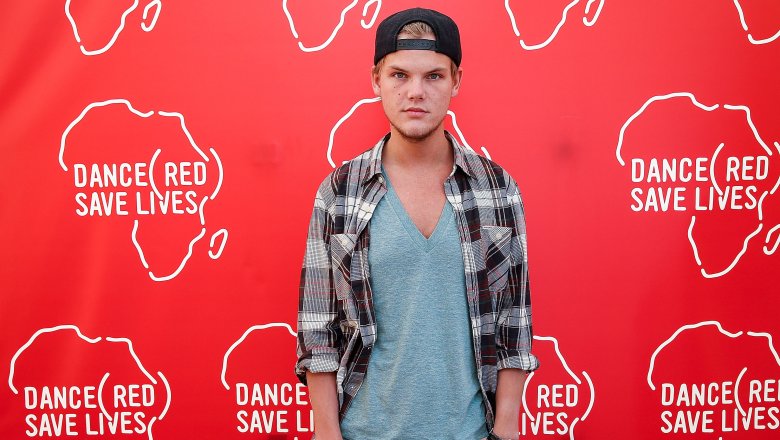 avicii in front of red sign