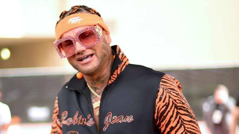 Riff Raff wearing a leopard print letterman jacket